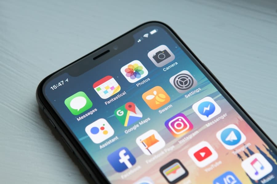 A smartphone home screen showing app icons, in the hands of a homeowner